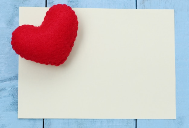 Красное сердце помещается на бумаге записку пустой для ввода текста или сообщения в дизайне.