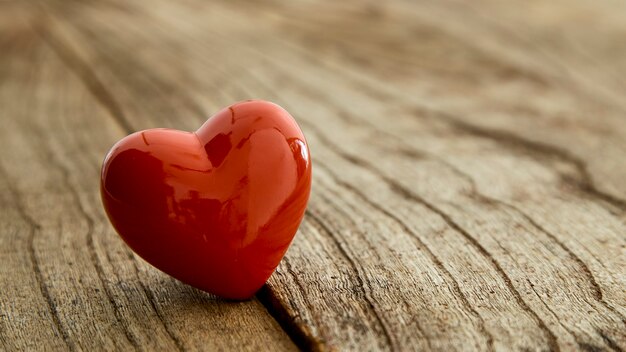 Красное сердце на деревенском старинном деревянном столе