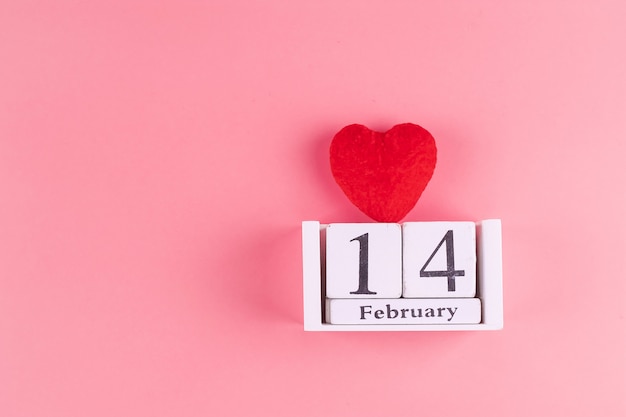 Red heart shape decoration with 14 February calendar on pink . Love, Wedding, Romantic and Happy Valentine day holiday concept