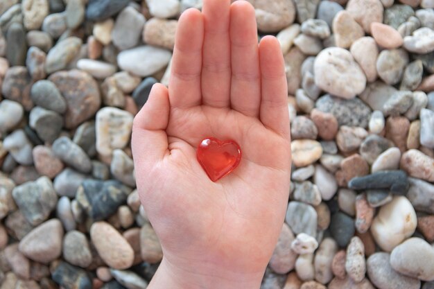 Foto forma di cuore rosso in mano sullo sfondo di pietra