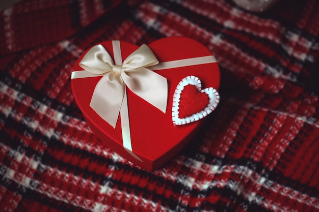 Red heart-shape present box with white bow and felt heart-shaped ornament