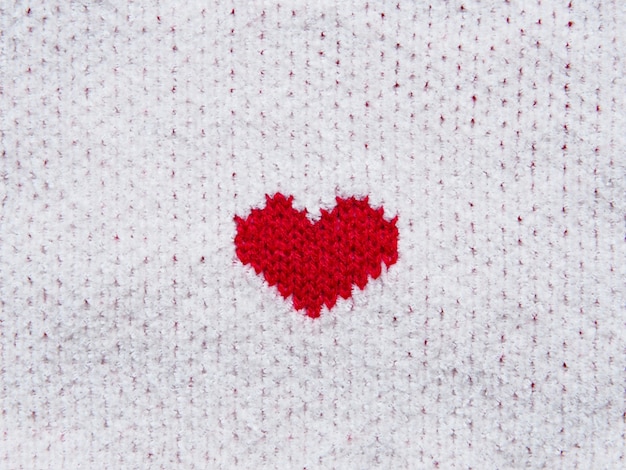 Red heart shape on white fabric texture. Valentine's day concept background.