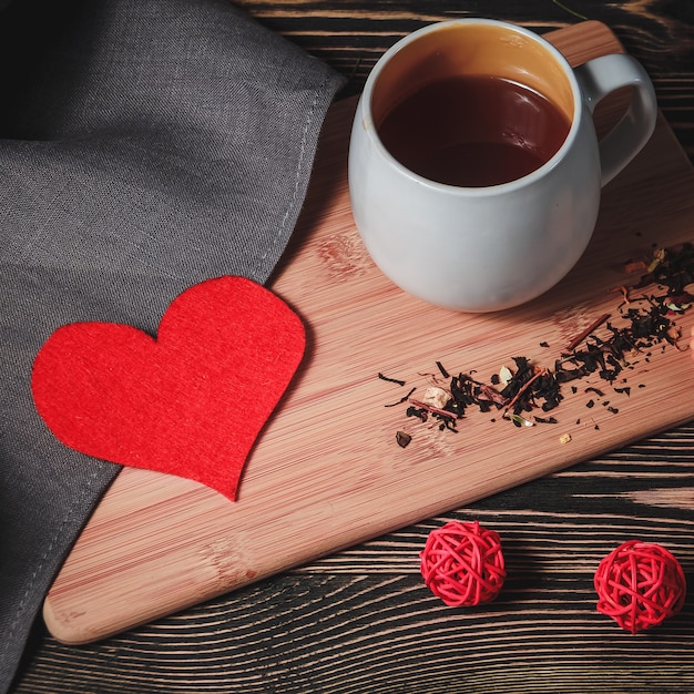 Red heart-shaped paper with cup of chocolate