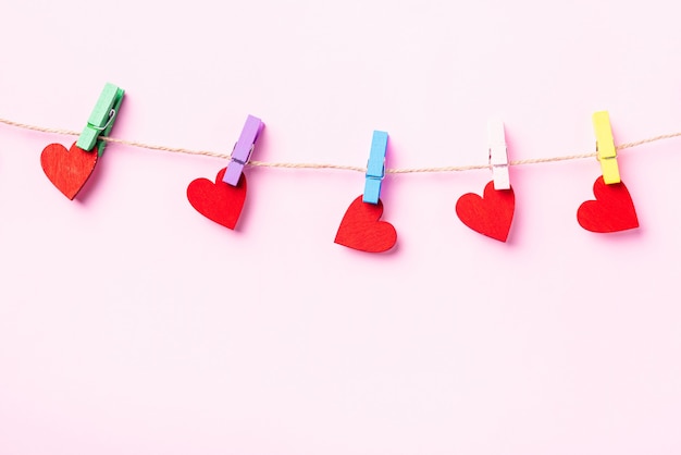 red heart-shaped valentines decoration hanging with wood clips