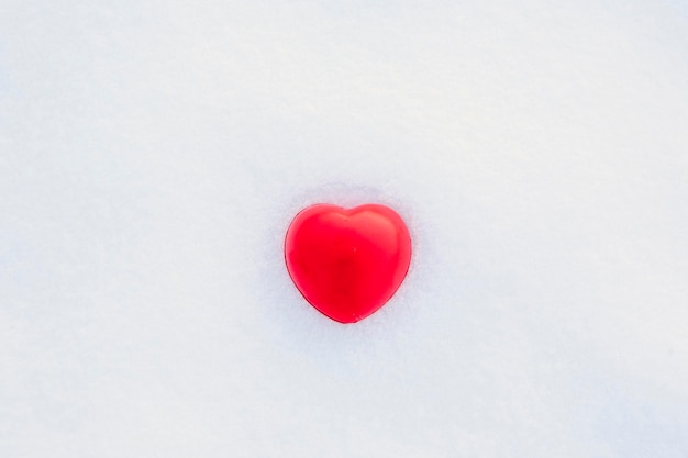 Foto cuore rosso nella neve