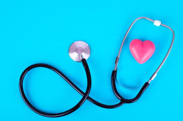 Red heart and a stethoscope on a blue background medical concept