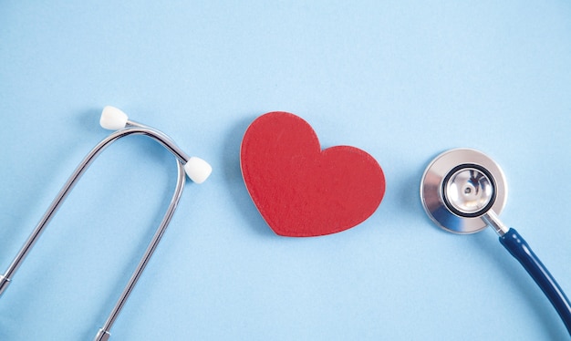 Red heart and stethoscope on the blue background.