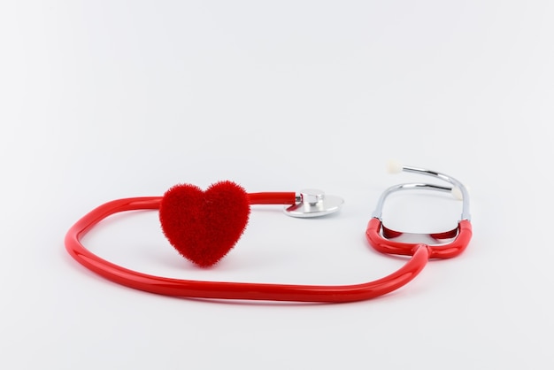 Red heart and a stethoscope on desk