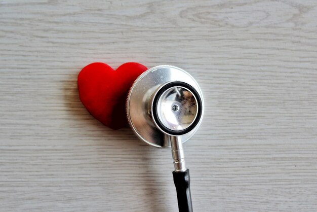 Red heart and stethoscope on white wooden background Healthcare and medical concept