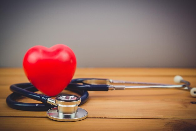 red heart and steythoscope on old wood table and world health day and healthcare