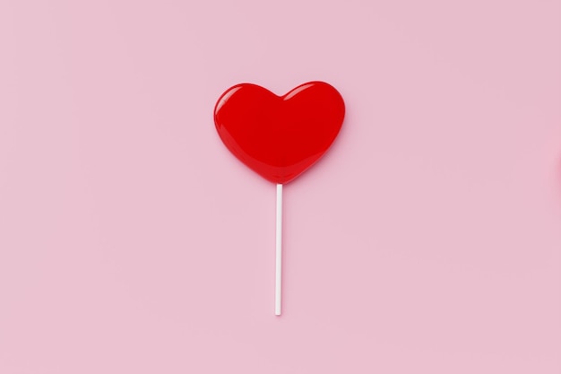 Red heart Sweet lollipop candy on pastel color background