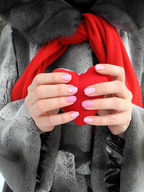 女性の手の赤いハートのシンボル