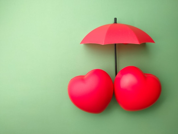 Red heart and umbrella on a green background