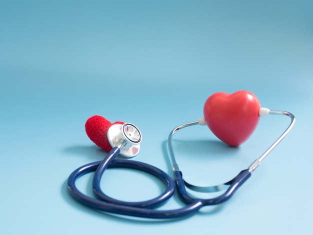 red heart using deep blue stethoscope on the blue background for hear their other heart.