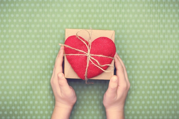 Фото Красное сердце с подарочной коробкой ко дню святого валентина на красивой зелени