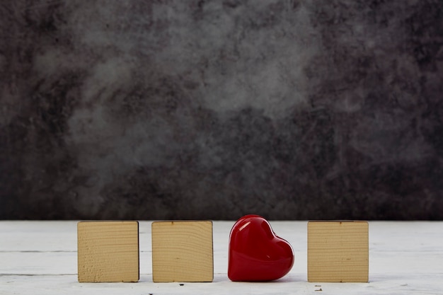 Red heart with Empty wood block on White wooden table