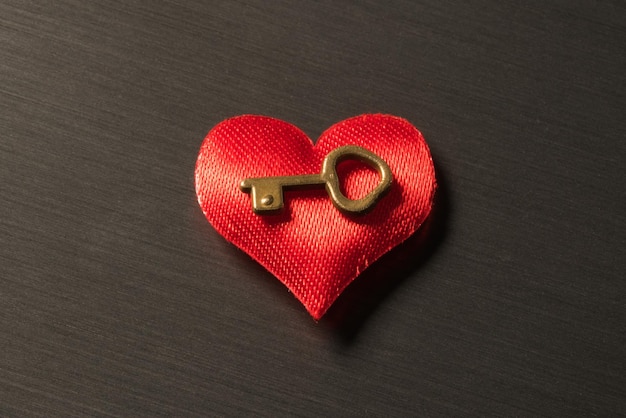 Red heart with the key on a metal surface