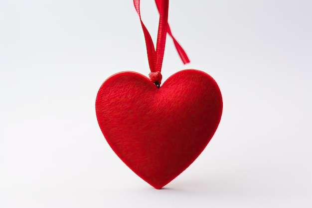 Photo a red heart with a ribbon attached to it in the style of romantic sensibility eyecatching tags