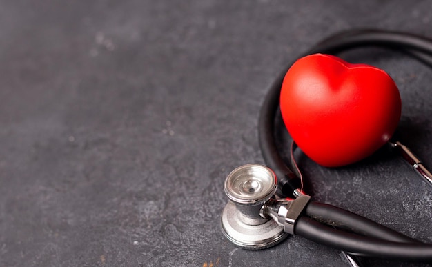 Red heart with stethoscope on dark background heart health health insurance concept World heart day