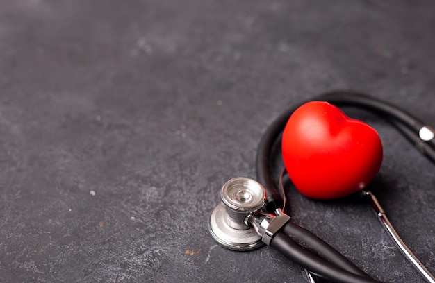 어두운 배경 심장 건강 보험 개념 세계 심장의 날에 청진기가 있는 붉은 심장