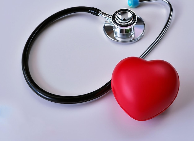 Красное сердце со стетоскопом на белом фоне