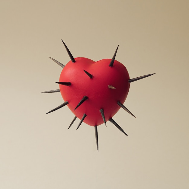 Photo red heart with thorns all over.  self love concept. self defense concept. minimal abstract  composition.