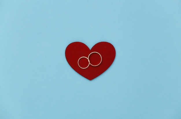 Red Heart with two gold rings on a blue background.