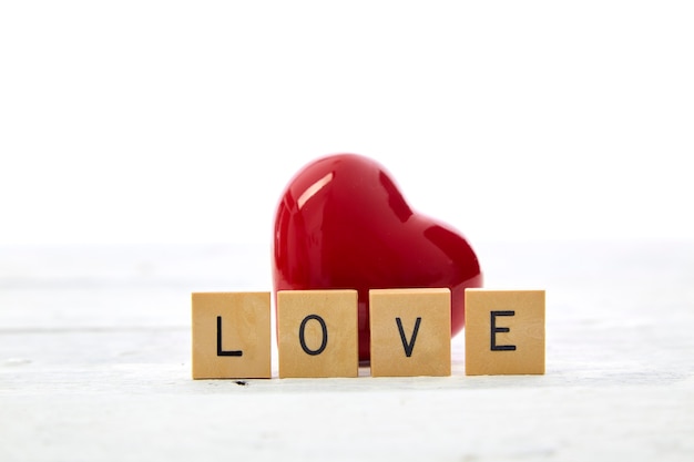 Красное сердце с текстом Дня святого Валентина любви Деревянные блоки письма на белом столе