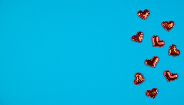 Red hearts on a blue background. Space for text