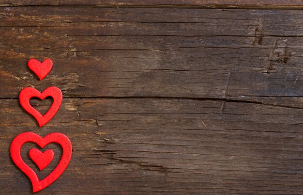 Red hearts on the brown wooden background