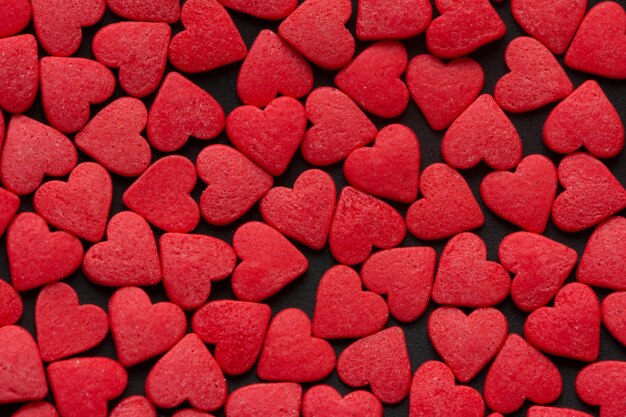 Red Hearts Candy on black surface close up Valentines day concept Macro Sweet red candy texture