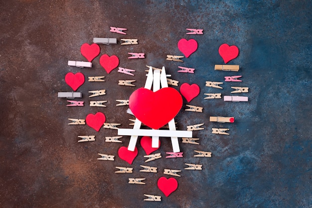 Red hearts and clothespins made heart isolated on stone background 