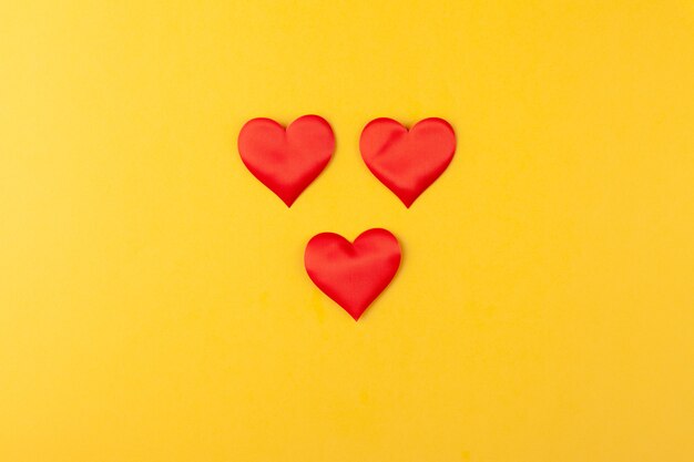 Red hearts on colored yellow background