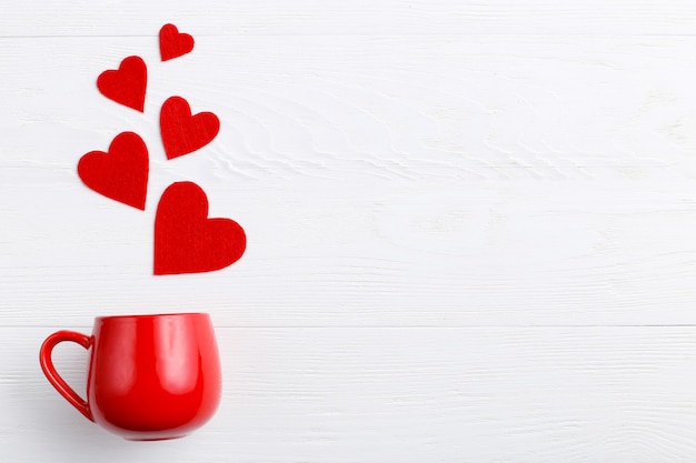 Red hearts coming out of the cup on white background