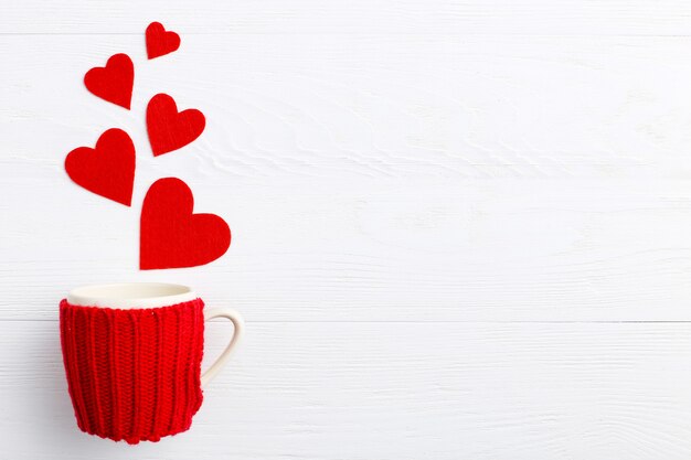 Red hearts coming out of the cup on white background