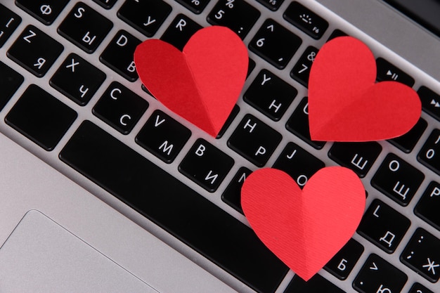 Red hearts on computer keyboard close up