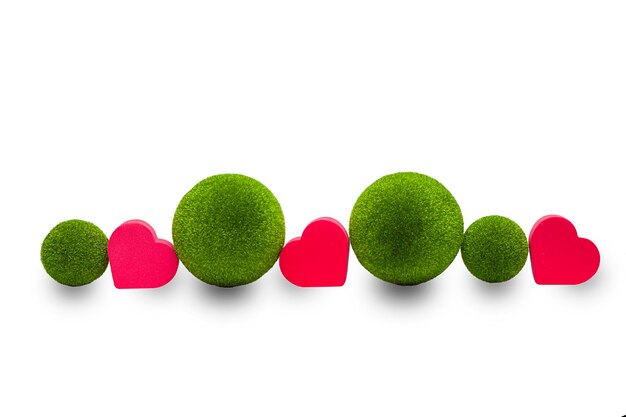 Red hearts and green balls isolated on a white background