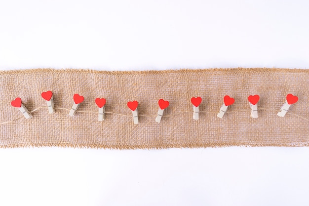 Red hearts hang on a brown string as a decoration for Valentine Day. Copy space