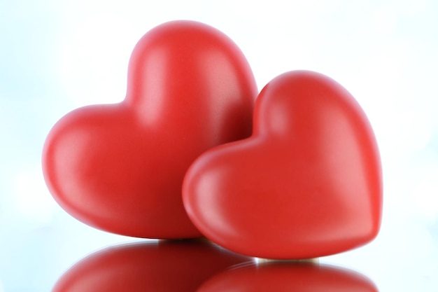 Red hearts on light background