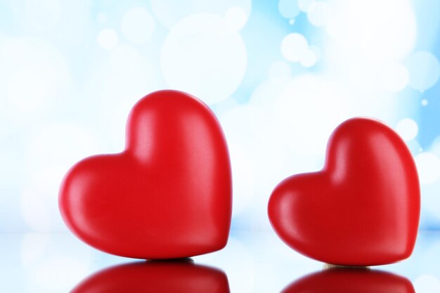 Red hearts on light background