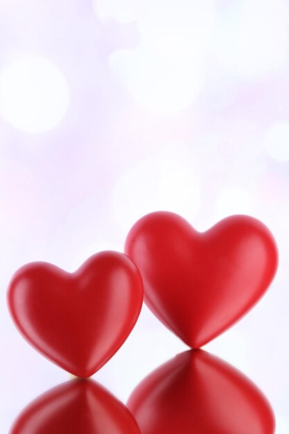 Red hearts on light background