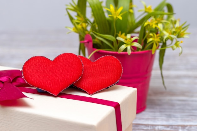 Red hearts near a bouquet of early spring flowers