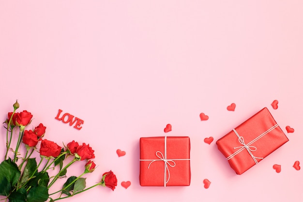 Red hearts, rose and gift box on pink background