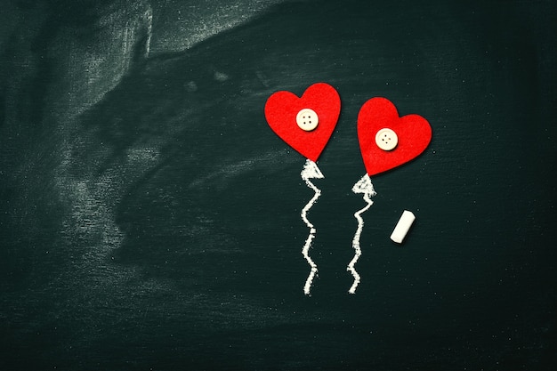 Red hearts on top of a blackboard