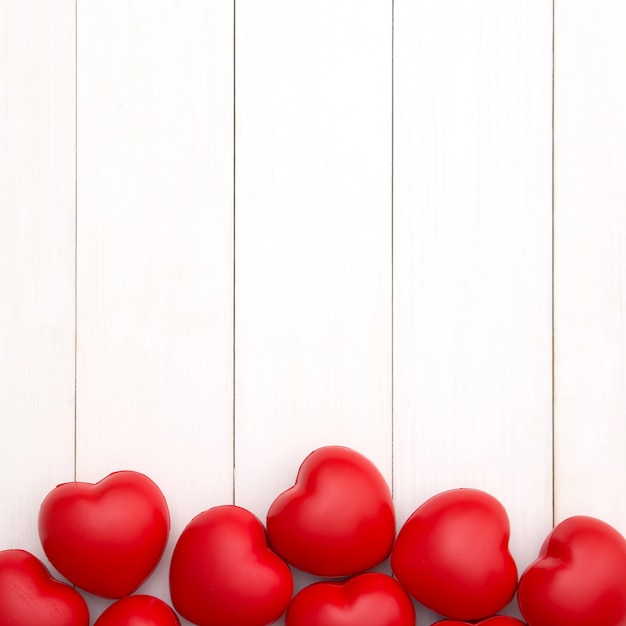 バレンタインデーのためのコピースペースと白い木製の背景に赤いハート。愛の概念最小限のスタイル