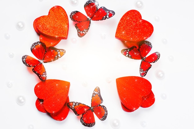 Red hearts with butterflieswhite background Frame made of hearts and butterflies