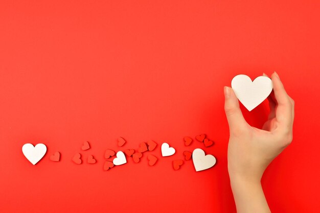 Red hearts in woman hand on a red background Copy space