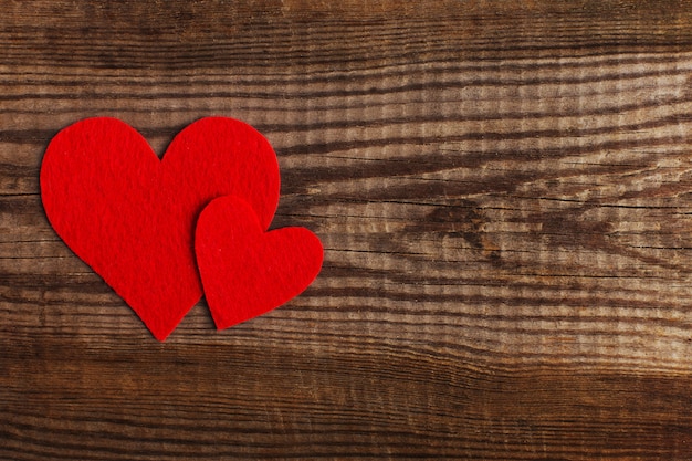 Red hearts on a wooden table. 