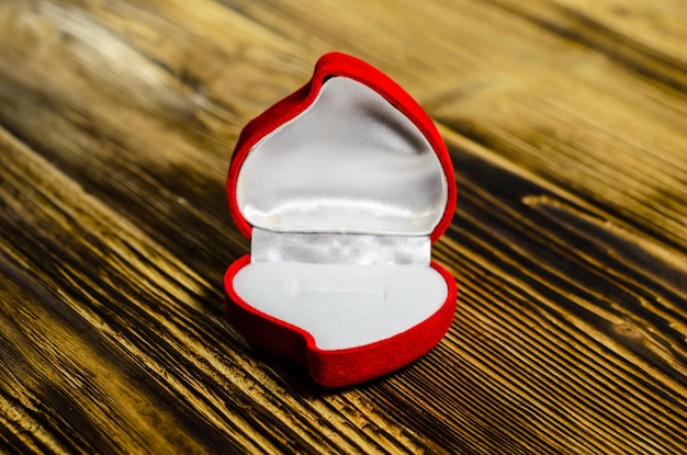 Photo red heartshaped jewelry box on a wooden table