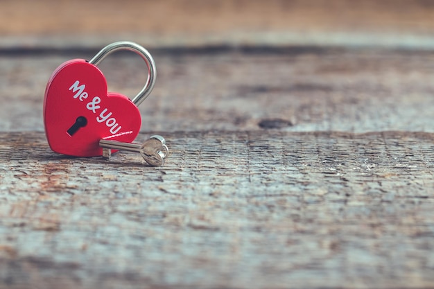 Красный замок в форме сердца с ключом на деревянном фоне День Святого Валентина или брак